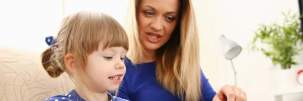 Carino bambina sul divano con mamma uso laptop — Foto Stock