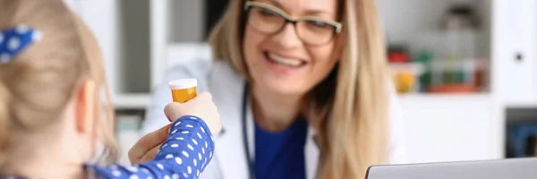 Beautiful smiling female doctor hold in arms pill