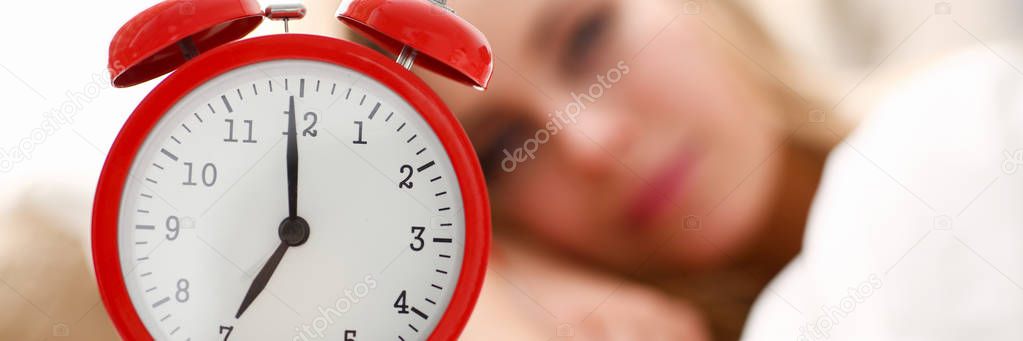 Young beautiful woman waking up in the morning alarm