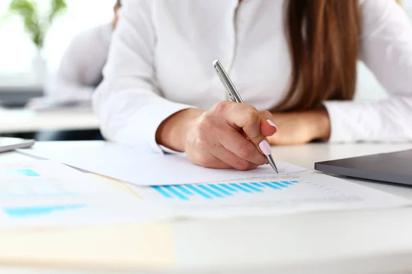 Female arm in suit hold silver pen and pad Stock Image