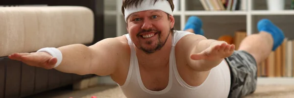 Young attractive fitness man lies on a fat mat with — Stock Photo, Image