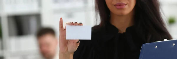 Vrouwelijke arm geven leeg telefoonkaart bezoeker — Stockfoto