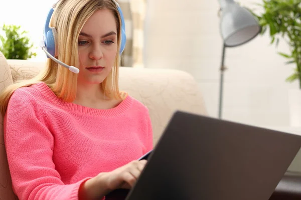 Jovem bela mulher loira sentar-se no sofá na sala de estar segurar aglutinante no trabalho de armas com laptop ouvir música — Fotografia de Stock