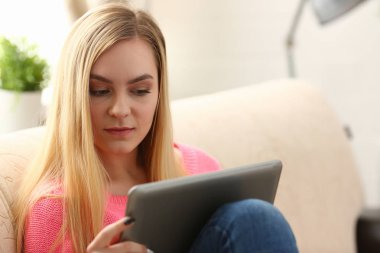 oturma odası Kanepe Otur genç güzel sarışın kadın kollarında tablet tutun