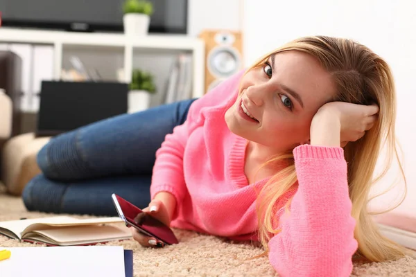 Молода красива блондинка на дивані тримає смартфон в руках — стокове фото