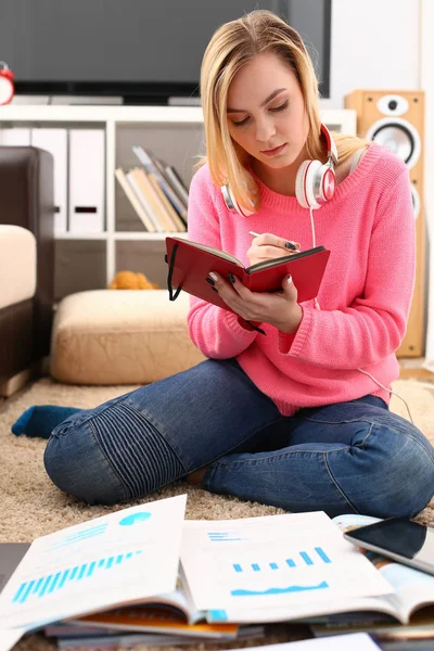 Молода красива жінка навчається у вітальні тримає книгу в руках — стокове фото