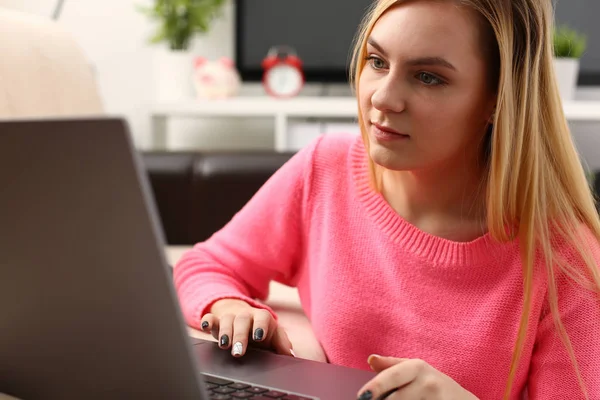 Joven hermosa mujer rubia sentarse en livingroom trabajo en el ordenador portátil — Foto de Stock