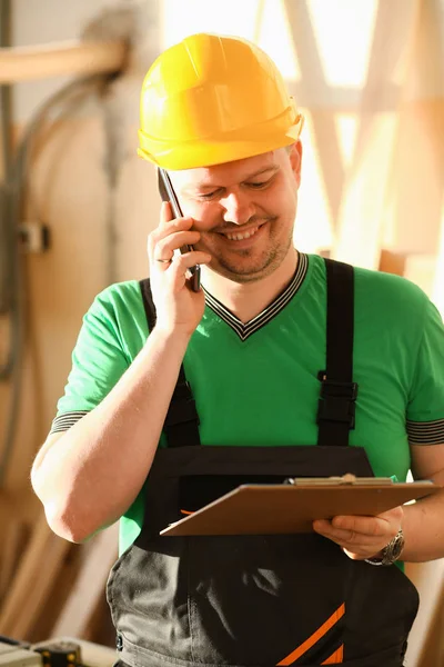 Timmerman aan de telefoon in de ijzerwinkel — Stockfoto