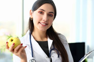 Kopya alanı mavi ile yeşil elma tutan doktor