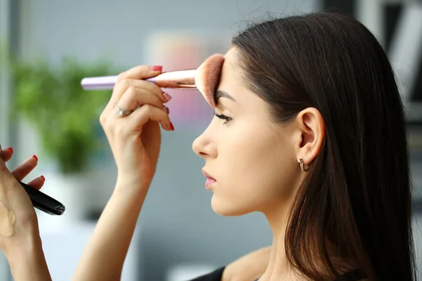 Young smiling beautiful brunette woman make her face up — Stock Photo, Image