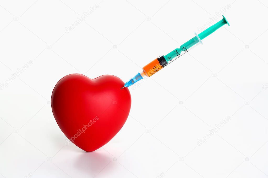 Red heart with stuck syringe on gray background