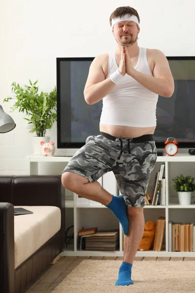 Un jeune homme pratiquant le yoga et le Pilates — Photo