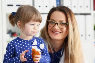 Küçük çocuk ile anne çocuk doktoru resepsiyonda
