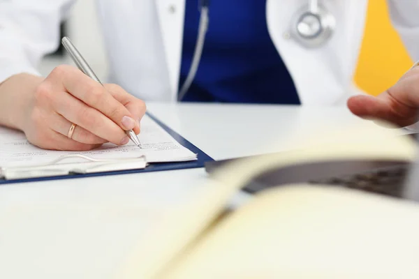 Mujer médico mano mantenga pluma de plata relleno paciente — Foto de Stock