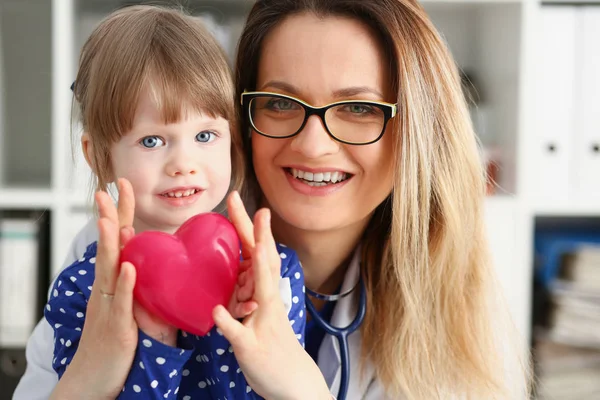 Kvinnliga läkare och litet barn håll i famn — Stockfoto