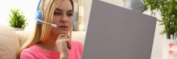 Jovem bela mulher loira sentar-se no sofá na sala de estar segurar laptop nos braços ouvir música — Fotografia de Stock