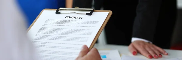 Male arm hold contract form clipped to pad