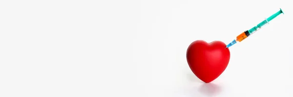 Red heart with stuck syringe on gray background