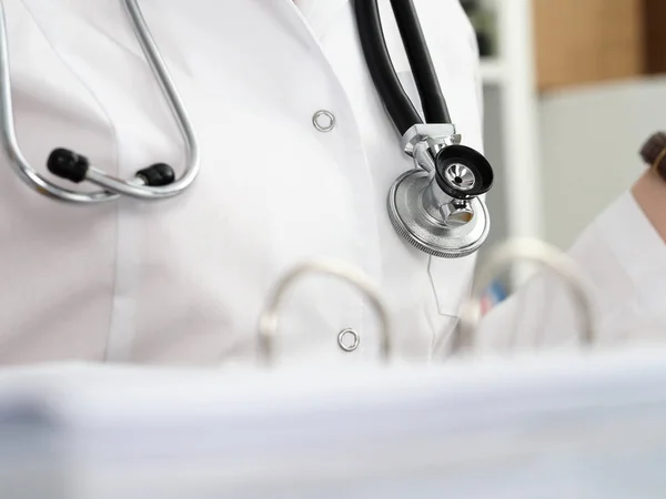 Stethoscope lying on female therapeutist doctor chest — Stock Photo, Image