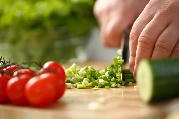 Cook holds knife in hand and cuts on — Stock Photo, Image