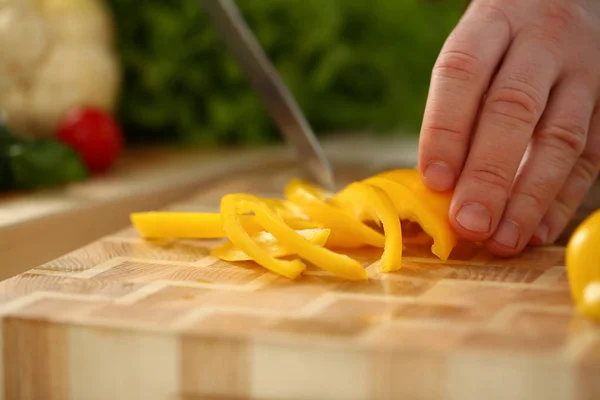 Cocinero sostiene cuchillo en la mano y cortes en —  Fotos de Stock