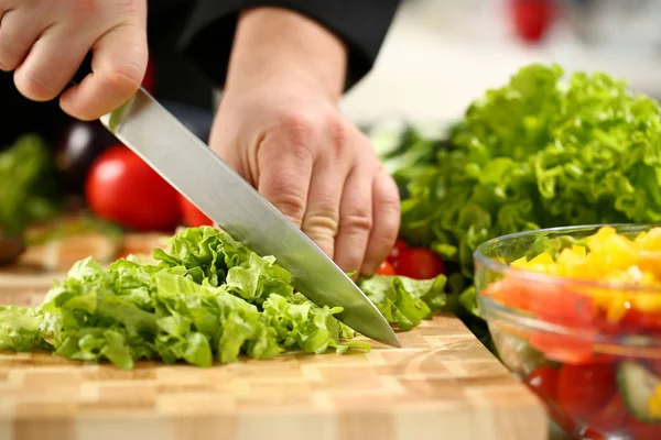 Koch hält Messer in der Hand und schneidet an — Stockfoto