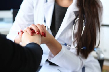 Genç kadın doktor hasta el ile tutar