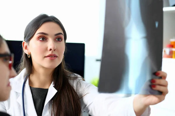 Femme beau médecin tenir dans le bras et regarder les rayons X — Photo