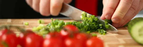 Cook holds knife in hand and cuts on