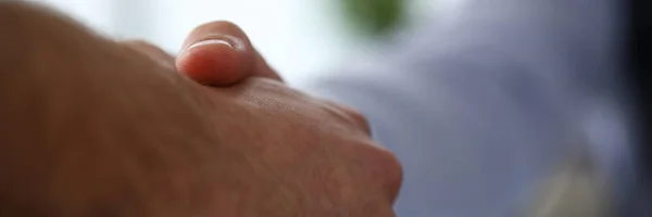 Man in suit and tie give hand as hello in office closeup