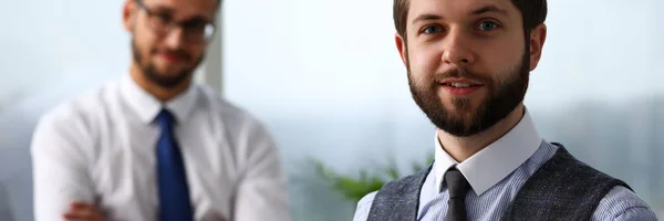 Stilig leende skäggiga kontorist man på arbetsplatsen titt i kameran — Stockfoto