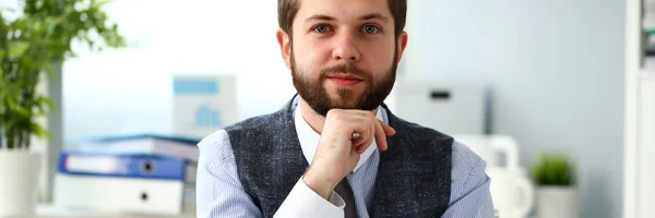 Guapo sonriente empleado barbudo en el lugar de trabajo de la oficina — Foto de Stock