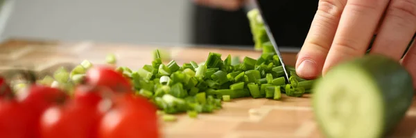 Cook holds knife in hand and cuts on