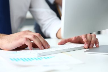 Bilgisayar pc kullanarak gümüş klavyede yazarak takım elbiseli erkek silah