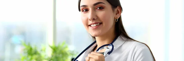 Mooie lachende vrouwelijke arts op werkplek portret — Stockfoto