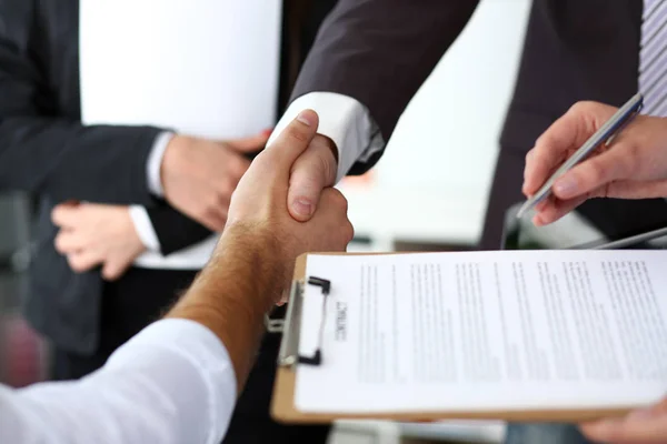 Man in suit and tie give hand as hello in office closeup