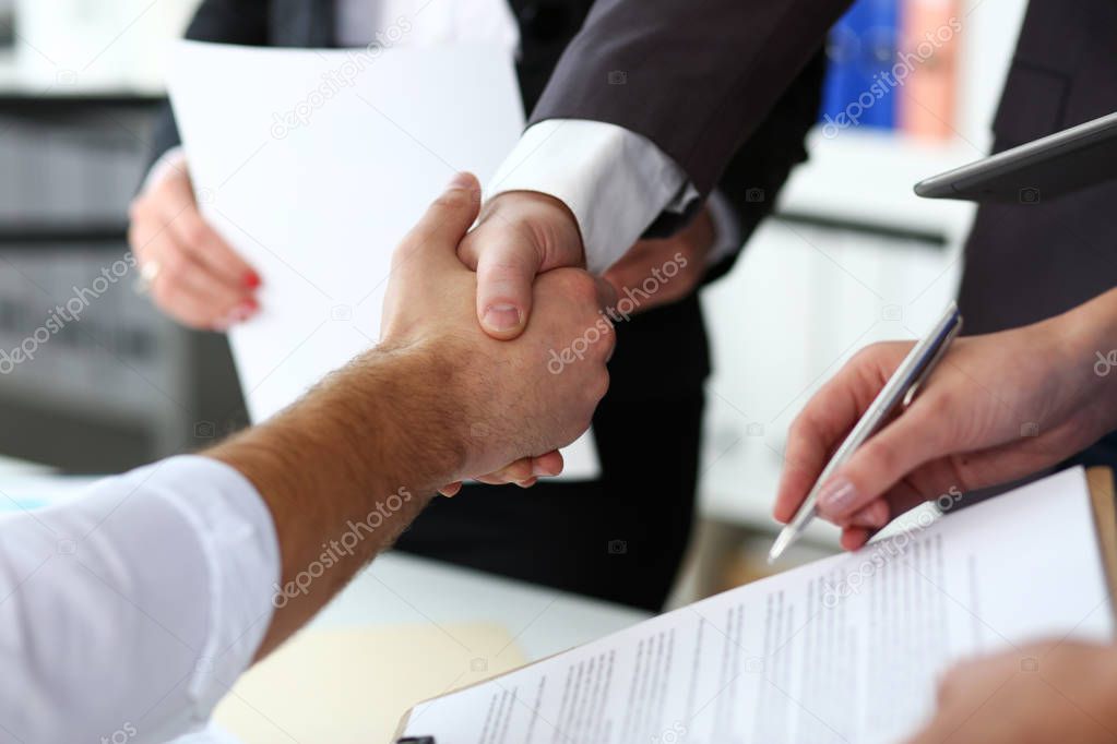 Man in suit and tie give hand as hello in office closeup