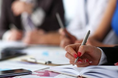 Kadın katip kol gümüş kalemiyle Not Defteri'nde işaretleri yapmak