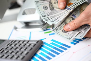 İşadamı nakit dolar ofiste inceliyor.