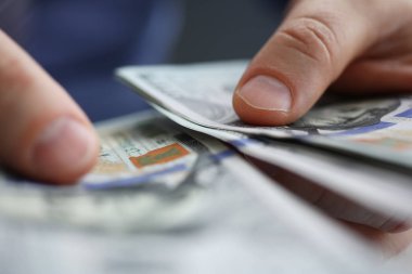 İşadamı nakit dolar ofiste inceliyor.