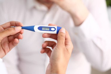bir termometre tutan kadın doktor eller