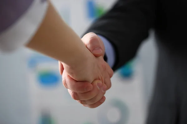 Man in suit and tie give hand as hello in office