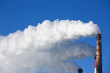 Beyaz duman boruları mavi gökyüzü karşı gelir