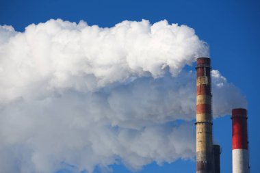 Beyaz duman boruları mavi gökyüzü karşı gelir