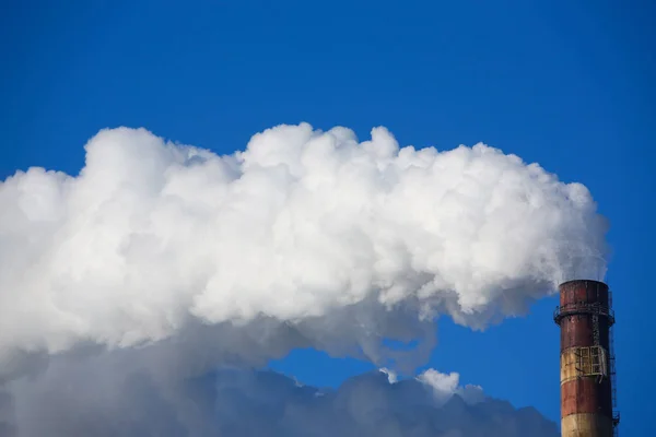 Beyaz duman boruları mavi gökyüzü karşı gelir — Stok fotoğraf