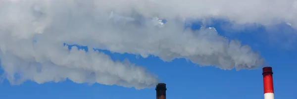 青い空を背景のパイプから白い煙が来る — ストック写真