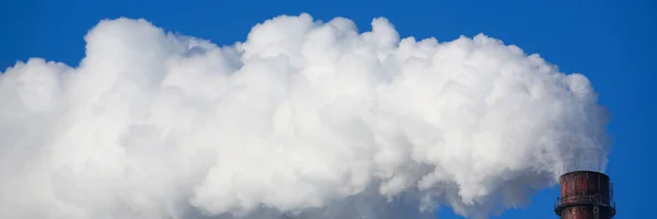 Il fumo bianco proviene dalle pipe contro il cielo blu — Foto Stock