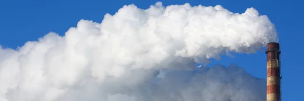 A fumaça branca vem de tubos contra o céu azul — Fotografia de Stock
