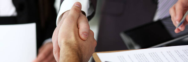 Мужчина в костюме и галстуке, поприветствуйте крупным планом.
