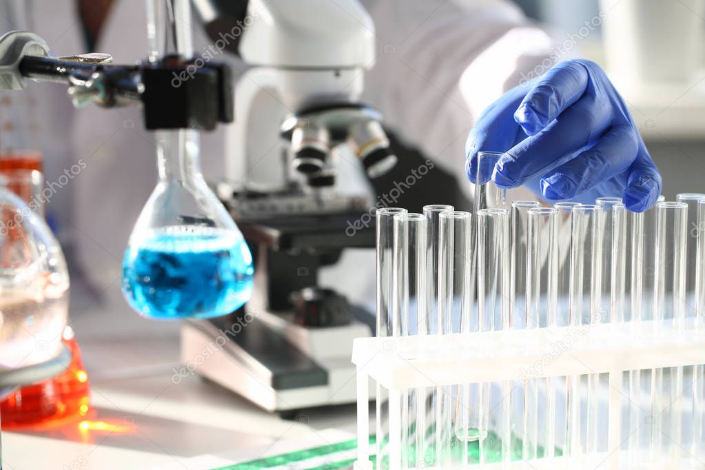 A male chemist holds test tube of glass in his hand